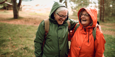 Two older women hiking and talking in nature 